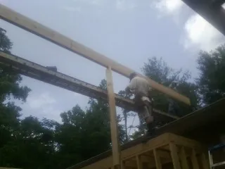Carpenter setting a ridge beam over a new addition frame — Ice Dam Removal by Roofing Brothers in Hopatcong