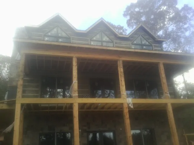 Dormers and porch framing on a large log home under construction — Roof Coating work by our crew in Hopatcong