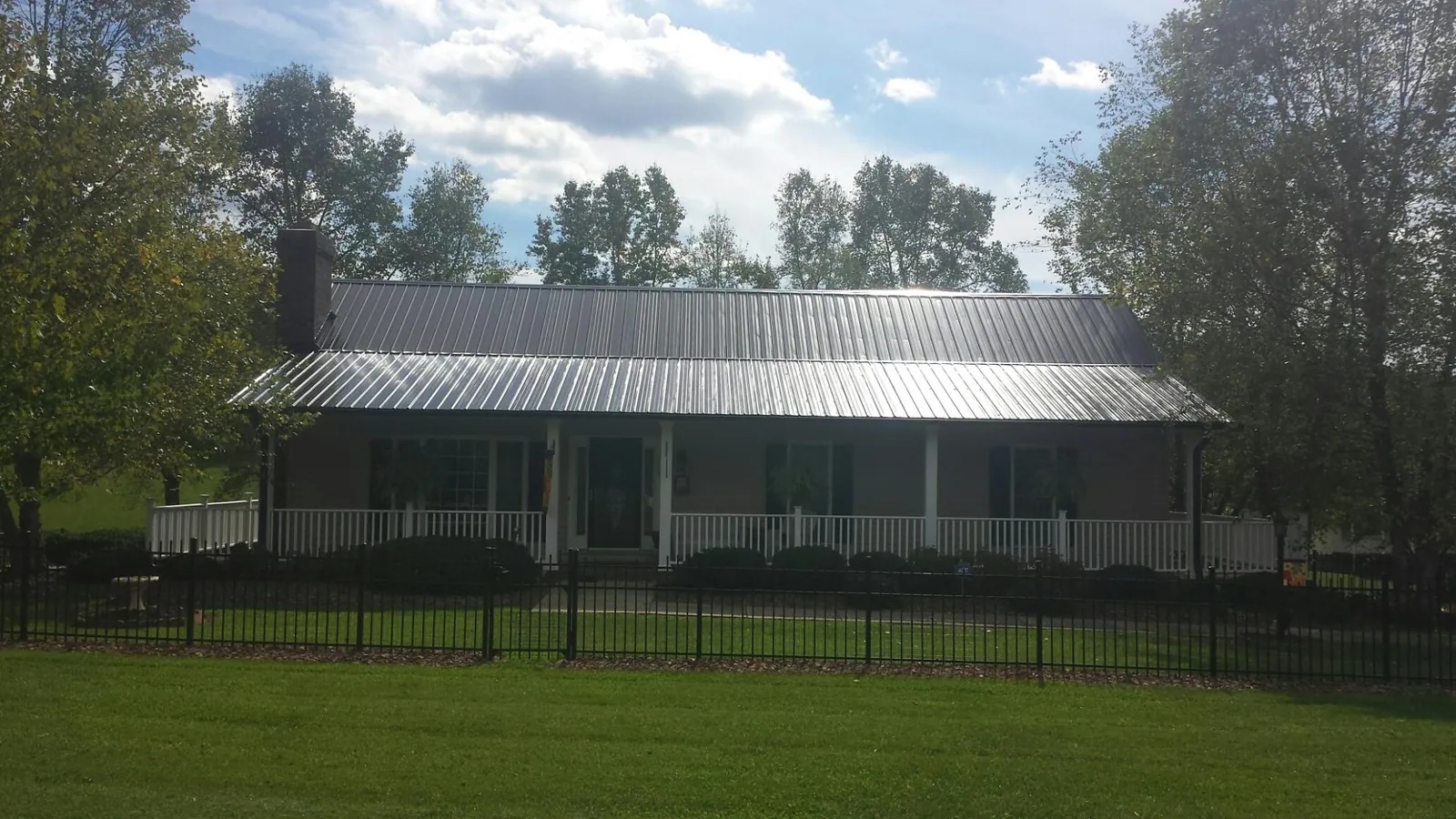 Gray metal roof on a brick ranch with a full width front porch — Gutter Guard Installation work by our crew in Hopatcong