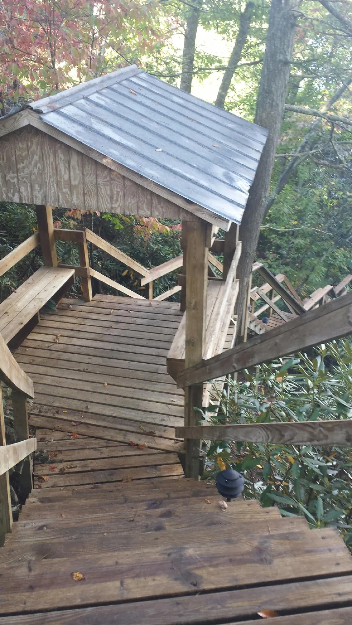 Metal roofed shelter over wooden steps on a wooded walkway — Skylight Repair & Installation work by our crew in Hopatcong